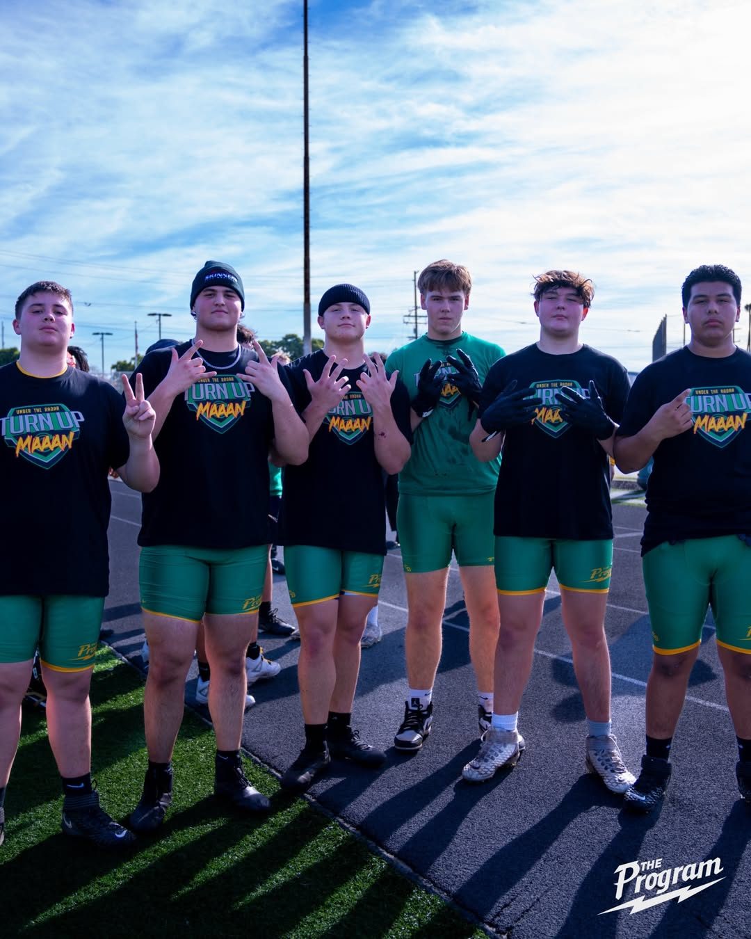 Program linemen standing together in green and black training kit
