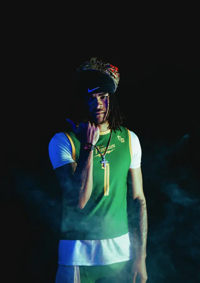 Program athlete number 1 in green wearing a crown and a cross chain