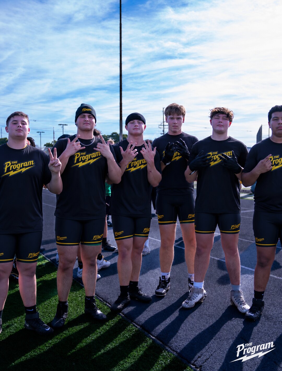 Program offensive and defensive linemen lined up on the field in team blackout kit